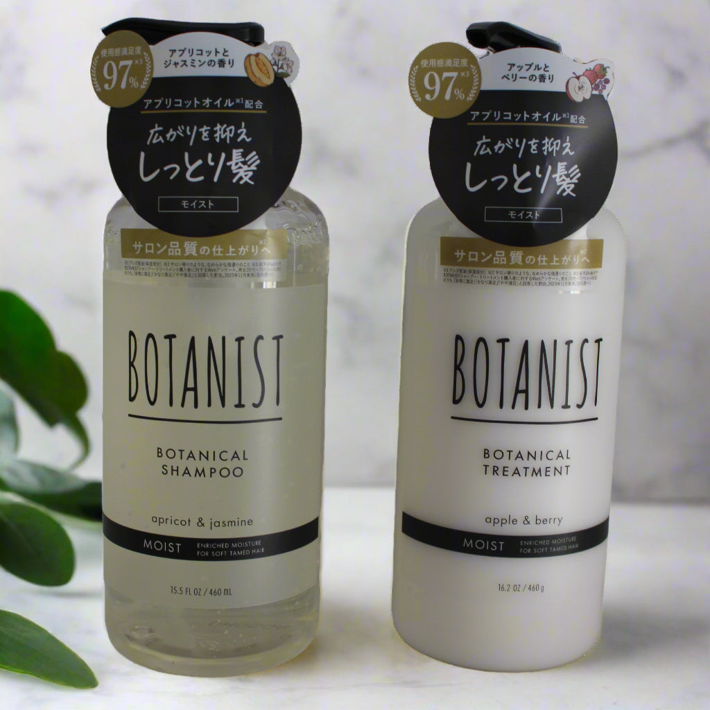 Two bottles of Botanist shampoo and treatment set on a light background with green leaves.